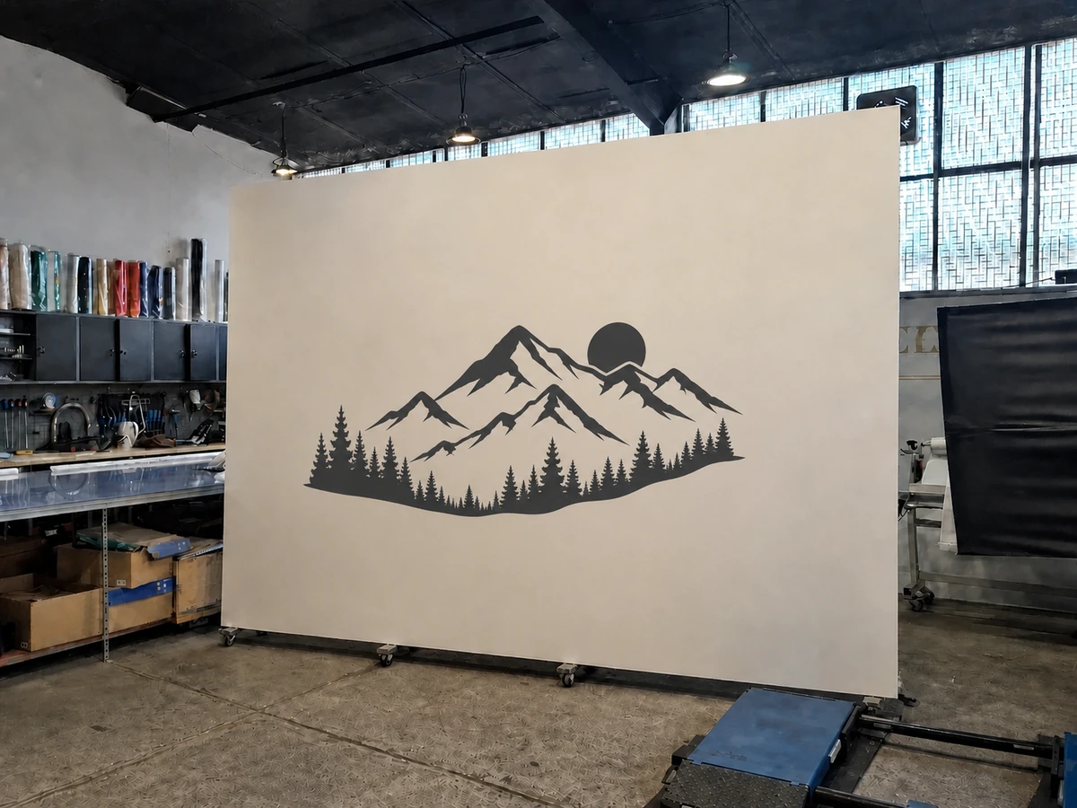 Wandtattoo mit Berg-, Wald- und Sonnenmotiv auf einer mobilen Musterwand in der Edelfoliert Werkstatthalle