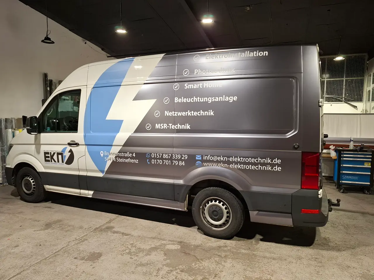 VW Crafter mit grau-matter Teilfolierung, blauem Blitz und Leistungen