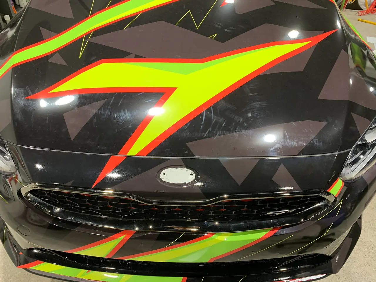 Motorhaube des Kia Ceed GT mit neongrünem Zackenmuster auf Schwarz