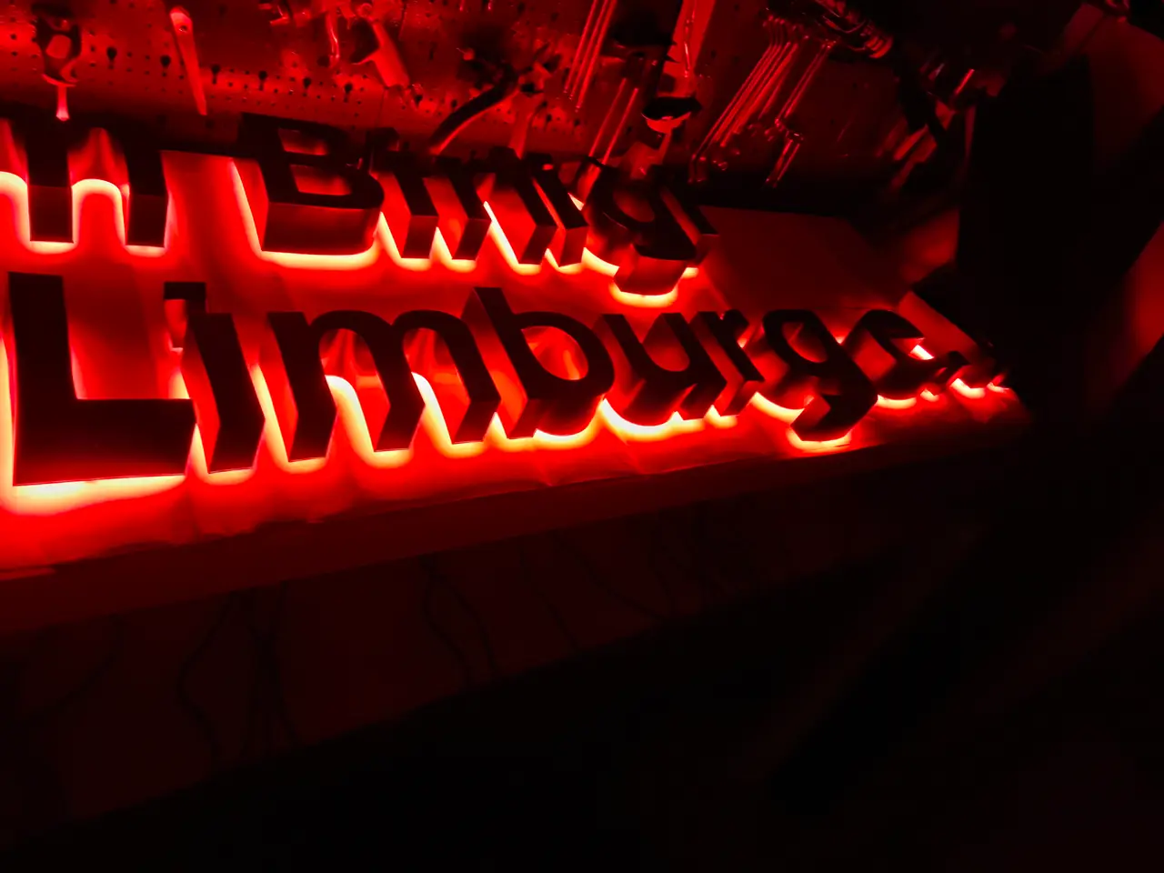 Rot leuchtende Buchstaben beim Lichttest in der dunklen Werkstatt